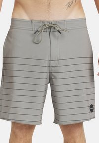 Hellgraue Boardshorts aus glattem Stoff, mit horizontalen schwarzen Streifen, elastischem Bund mit Kordelzug und einem Logo-Patch.