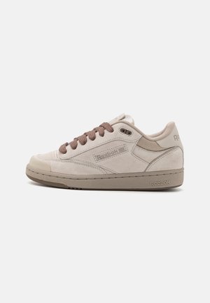 Baskets Reebok beige clair avec lacets marron, dessus en daim et logos de la marque sur le côté, la languette et la semelle, vues de l'extérieur.