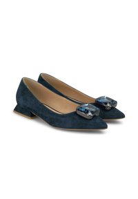 Ballerine in camoscio blu navy con punta appuntita, caratterizzate da un grande particolare in gemma blu sul collo del piede e un piccolo tacco a blocco per maggiore stabilità.