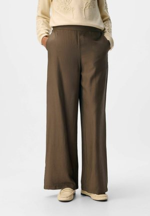 Braune, weite Hosen aus leichtem Material mit strukturiertem Finish. Mit Seitentaschen und elastischem Bund.