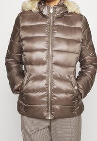 Hnědá puffer bunda s horizontálním prošíváním, zipovým zapínáním, dvěma předními kapsami a odnímatelným umělým kožíškem na kapuci.