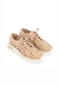 Baskets beiges tissées avec lacets, affichant un design perforé, une semelle blanche et une subtile touche beige au niveau du talon.