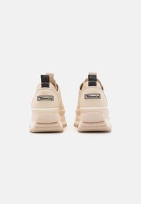 Béžové sportovní boty s texturovaným svrškem, s černým poutkem, logem a robustní, vrstvenou podešví.
