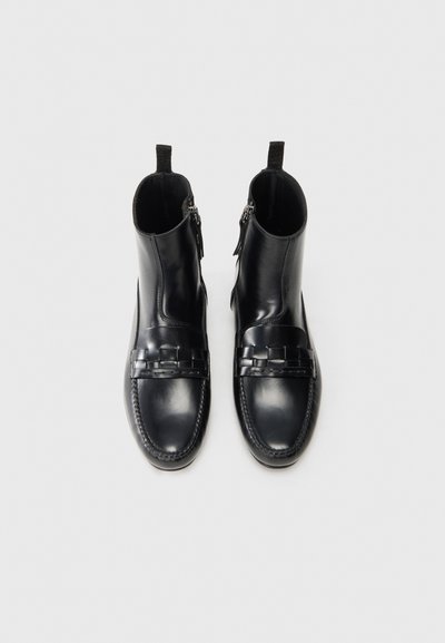 Svarta läderankelboots med en slät finish, dragkedjestängning och vävd detalj framtill. Har en rundad tå och texturerad sula.