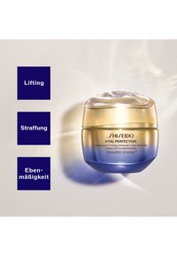 Shiseido Vital Perfection-crèmepot met een goudblauwe verloopkleur, gladde textuur, ronde vorm en transparant deksel met een spiraalpatroon.