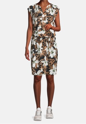 Robe florale à manches capes, fond noir, imprimé floral blanc et marron, taille cintrée, longueur genoux, portée avec des chaussures de sport grises.