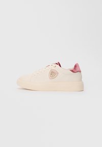 Baskets crèmes avec semelle épaisse, languette en velours rose à l'arrière, système de laçage sur le devant et logo en forme de bouclier avec accents dorés sur le côté.