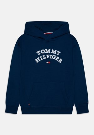 Granatowa bluza z kapturem z przednią kieszenią, ściągaczami na mankietach oraz białym napisem i logo "Tommy Hilfiger" na piersi.