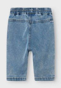 Heledad teksased helesinis, elastse vöökohaga, sujuva tekstuuriga ja sirge lõikega. Ilma taskuteta, lihtsad õmblusdetailid.