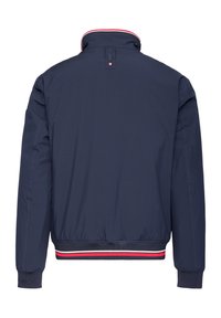 Marineblaue Bomberjacke mit gerippten Bündchen und Saum, roten und weißen gestreiften Akzenten und hohem Kragen, von hinten betrachtet.