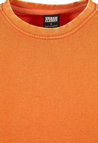 Camisa naranja de manga corta hecha de tejido acanalado. Presenta un cuello redondo con una etiqueta que dice "URBAN CLASSICS" y tamaño "S."