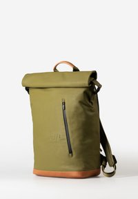 Zaino a forma di tubo di colore verde oliva con una base in pelle marrone chiaro, dotato di una cerniera laterale, spallacci regolabili e un dettaglio con logo in rilievo sul fronte.
