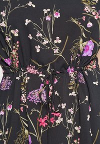 Schwarzes Stoffkleid mit floralen Mustern in verschiedenen Rosa- und Lilatönen, mit Kordelzug in der Taille und weicher Textur.