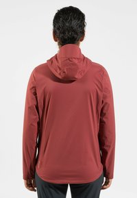 Red waterproof jacket with a hood, featuring a smooth texture, long sleeves, and an adjustable collar. Logo on the lower side.