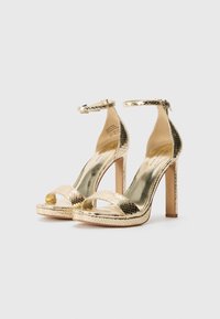 Goldene Leder-High-Heelsandalen mit einer strukturierten Schlangenleder-Oberfläche, offener Zehe, Knöchelriemen und einer glatten metallischen Innensohle.