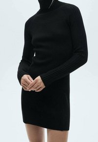 Robe noire en tricot avec un col roulé haut, des accents de manches côtelés, une silhouette ajustée et une longueur mi-thigh. Texture douce.