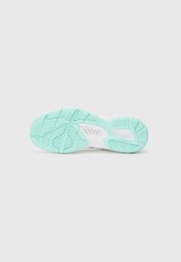 Schuhsohle mit einer strukturierten, helltürkisen Gummifläche, die Rillen und Muster für besseren Halt aufweist, auf einem weißen Untergrund.