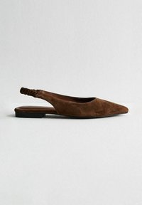Chausson plat slingback en suède marron avec un bout pointu, surface texturée et détail élastique au talon. Talon bas et carré.