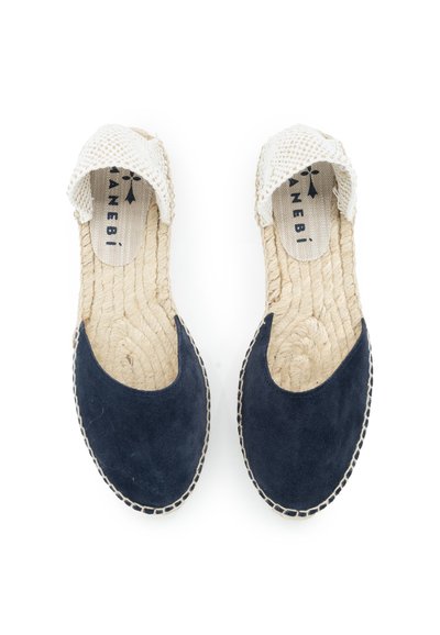 Marineblaue Wildledersandalen mit beigen Häkelakzenten, geflochtener Jutesohle und kontrastierenden Nähdetails entlang des Randes.