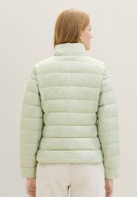 Helle grüne, bauschige Jacke mit horizontalen Steppnähten, hohem Kragen und glatter Textur. Normale Passform, ausgelegt für Wärme und Komfort.