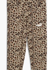 Leggings in stampa leopardata beige con macchie nere e arancioni. Presentano una texture liscia e un piccolo logo bianco nella zona fianchi.