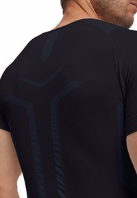 Czarna koszulka sportowa z teksturowanymi akcentami w ciemnoniebieskim kolorze, z odblaskowymi detalami i dopasowanym krojem. Krótkie rękawy i bezszwowa konstrukcja.