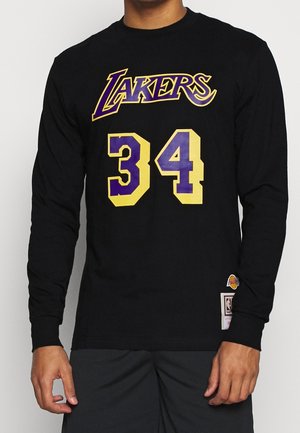 Schwarzes Langarmshirt mit lila und gelbem "Lakers"-Schriftzug und der Nummer 34 auf der Vorderseite, getragen von einer Person mit entspannt an den Seiten herabhängenden Händen.