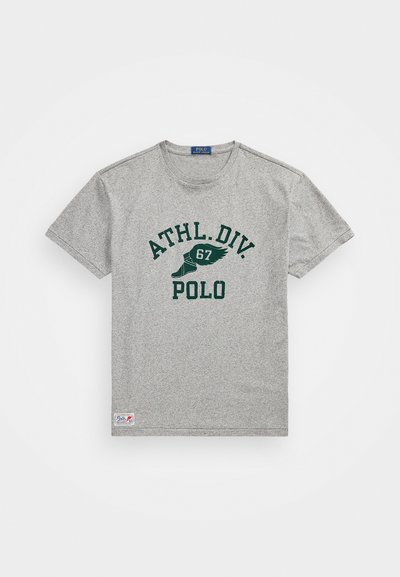 Pilkas trumpas rankovėmis marškinėliai su apvalia kaklo iškirpte, ant kurių yra žaliai spausdintų užrašų "ATHL. DIV. 67 POLO" ir logotipo pataisa apačioje.