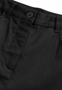 Crne tkanine hlače s glatkom teksturom, pojasom s petljama za remen i jednim crnim gumbom naprijed.