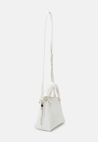 White leather handbag with a structured design, two top handles, a long adjustable strap, gold-tone hardware, and a zip closure.