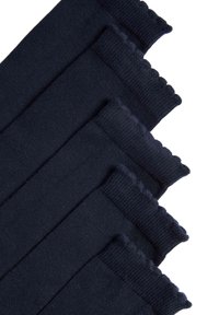 Námořnické ponožky s vlnitými okraji, vyrobené z hladkého pleteného materiálu, úhledně složené do vrstev, s rovnoměrnou barvou a konzistentní texturou.
