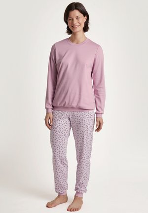 Lichtroze longsleeve top gecombineerd met gestreepte pyjamabroek met kleine bloemenpatronen. Zacht materiaal, elastische manchetten aan de broek.