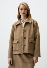 Giacca in camoscio marrone con colletto classico, quattro tasche frontali e chiusura a bottoni. Presenta una vestibilità rilassata e una texture liscia.