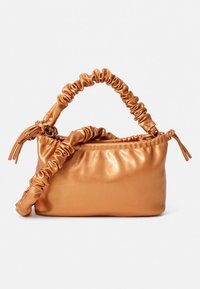 Leather handbag with a smooth, metallic finish in warm copper color. Features gathered handle and accented side tassels.