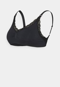 Reggiseno nero con coppe morbide e bordo in pizzo sulle coppe e spalline regolabili su sfondo bianco.