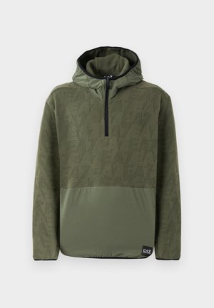 Pull à capuche en vert olive, présentant un tissu supérieur texturé et une section inférieure unie. Ouverture zippée au niveau du cou et accents noirs.