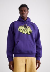 Paarse hoodie van een katoenmix, met een groot gele grafisch ontwerp op de voorkant, een kangoeroezak en een verstelbare trekkoordkap.