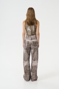 Completo due pezzi in tonalità beige e grigio, composto da un top fitted senza maniche e pantaloni a vita alta, morbidi e dal taglio ampio, con un motivo testurizzato e marmorizzato.