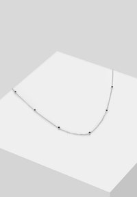 Sølv kædedesign med små sorte perler fordelt langs ledningerne, der viser et delikat design med en glat overflade.