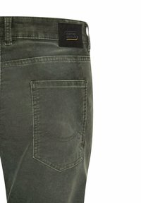 Mørkegrønne bomuldsbukser med en baglomme med syninger og en mærkeplade på linningen.