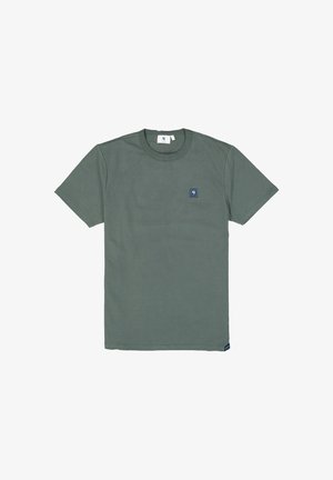 Grünes Baumwoll-T-Shirt mit kurzen Ärmeln, Rundhals und einem kleinen blauen Logo-Patch auf der linken Brust. Glatte Textur, schlichtes Design.