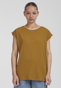 Senapsgul kortärmad t-shirt med rund halsringning och vikt ärmar. Tillverkad av mjuk bomull, har den en avslappnad och boxig passform.