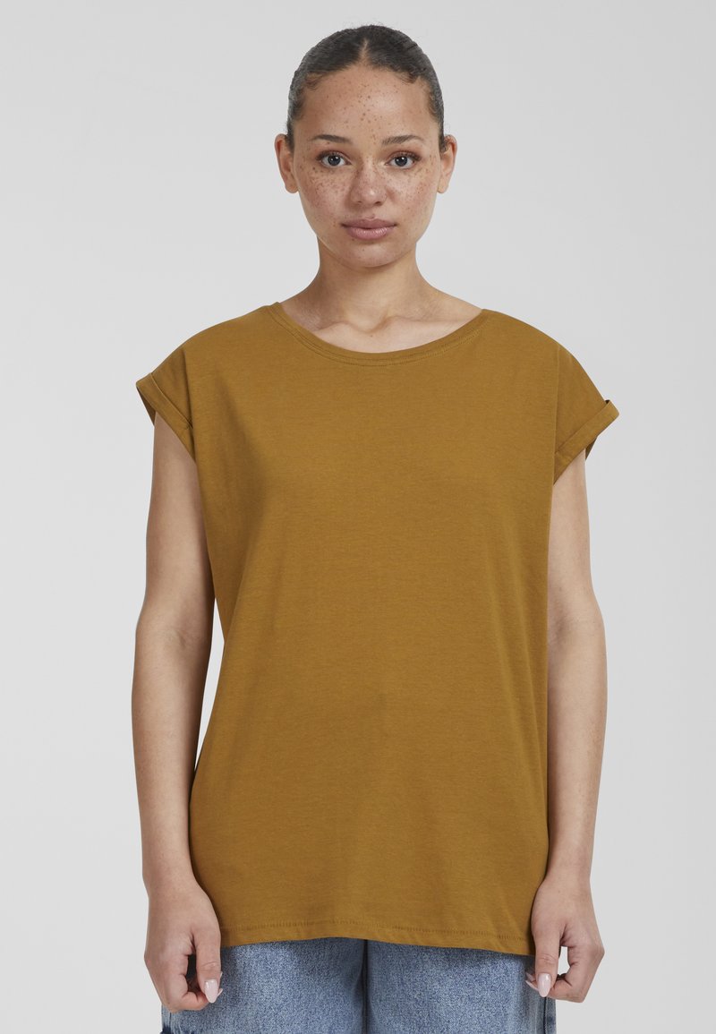 Senapsgul kortärmad t-shirt med rund halsringning och vikt ärmar. Tillverkad av mjuk bomull, har den en avslappnad och boxig passform.