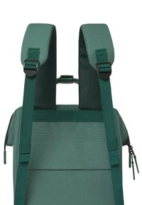 Grüner Stoff-Rucksack mit verstellbaren Trägern, einem Handgriff oben und Reißverschluss. Verfügt über stabile Nähte und eine glatte Textur.