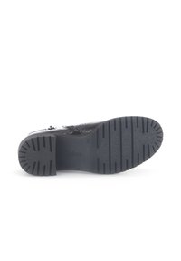 Zwarte veterschoenen met een gestructureerde bovenkant, stevige rubberen zool met ribbels en subtiele merknaam op de binnenzool.