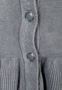 Szary, dziany kardigan z prążkowaną teksturą, dwoma dużymi guzikami i plisowanymi detalami u dołu. Materiał wydaje się miękki i elastyczny.