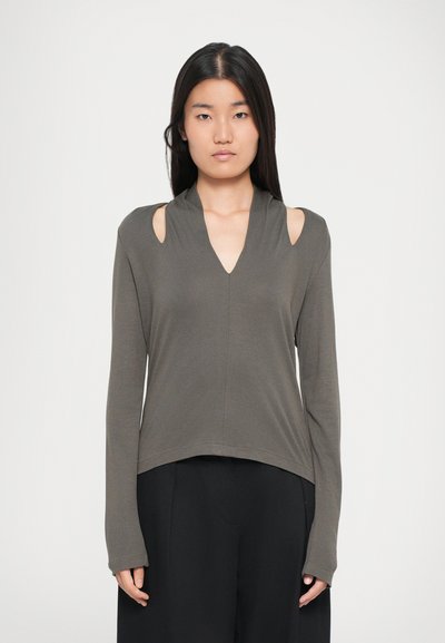 Maglia a maniche lunghe in verde oliva, con scollatura a V, dettagli sulle spalle a taglio e vestibilità rilassata, realizzata in tessuto morbido e testurizzato.