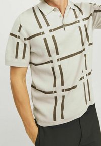 Kortärmad polo i ljusgrått med ett geometriskt brunt mönster, med klassisk krage och knappslå med två knappar, tillverkad i stickad tyg.