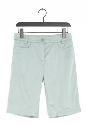 Pantalones cortos verde claro hasta la rodilla con cierre de botón, bolsillos frontales y una textura suave, colgando de una percha de plástico negro.