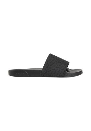 Sort slip-on sandal med tekstureret geometrisk mønster på bred rem og polstret sål, set fra siden på hvid baggrund.